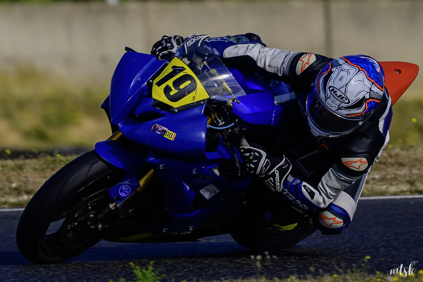 Pilote moto en pleine inclinaison sur circuit